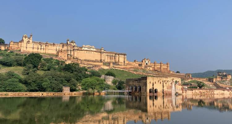 Fort d'Amber se reflétant dans un plan d'eau avec un ciel bleu.