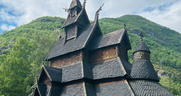 Église traditionnelle en bois debout sur fond de montagnes.