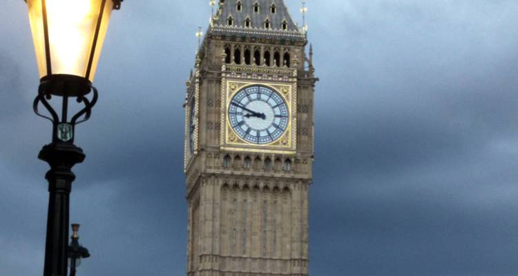 Big Ben clock tower illuminated against a dark sky.
