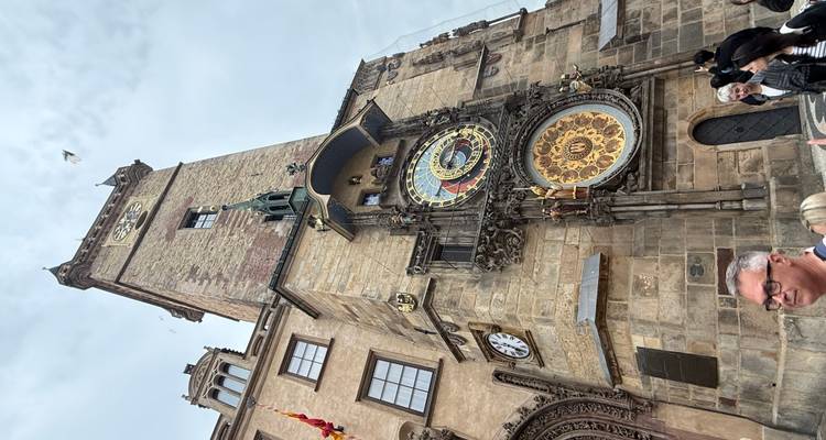 Tour d'horloge astronomique avec des personnes au premier plan.