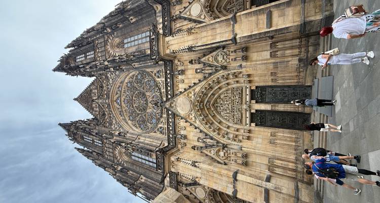 Entrée de cathédrale gothique avec sculptures complexes et des gens devant.