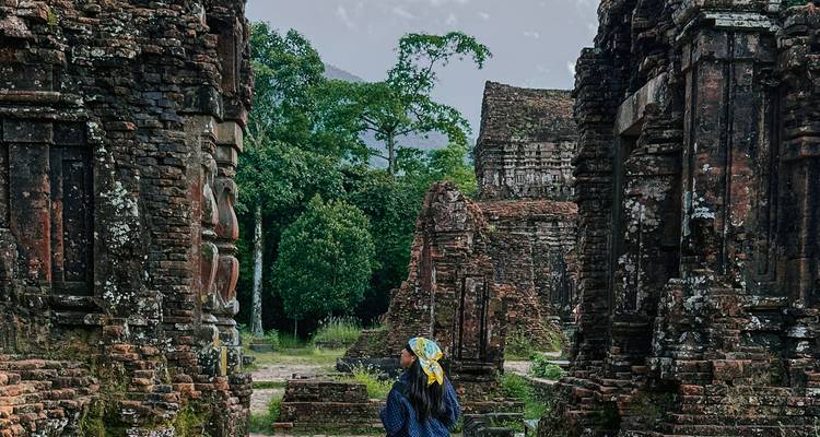 A person exploring ancient ruins, likely My Son Sanctuary.
