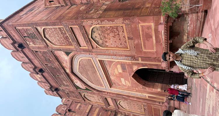 Une personne debout devant le Fort d'Agra.