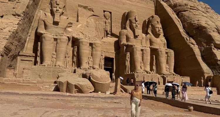 People visiting large statues carved into rock