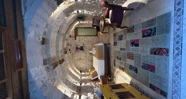 Chambre aux murs de pierre avec lit et tapis.