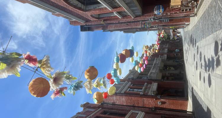Rue avec des lanternes colorées et des bâtiments en brique.
