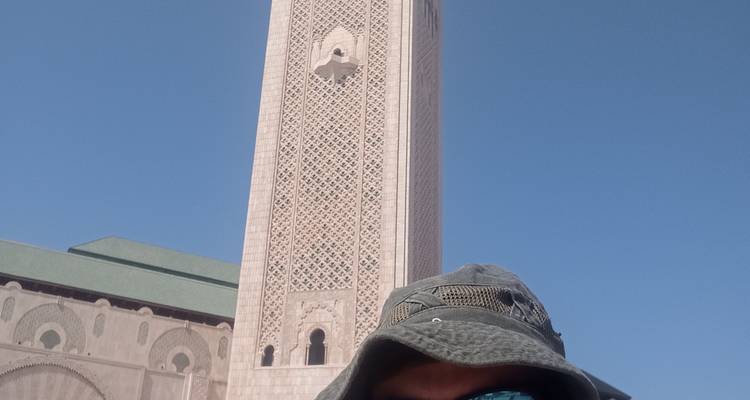 Blue-painted street with decorative hats on walls.