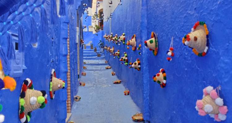 Ruelle étroite peinte en bleu avec des marches qui montent.