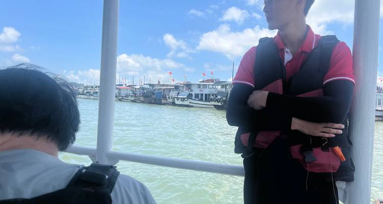 Lighthouse on a cliff face with grassy landscape.