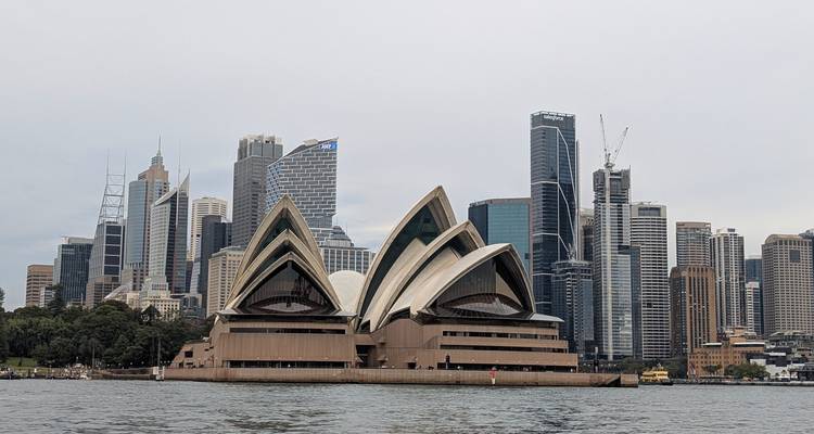 Sydneyer Opernhaus und Stadtsilhouette unter einem bewölkten Himmel.