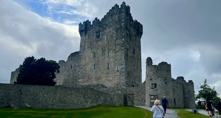Stone castle building with cloudy sky.