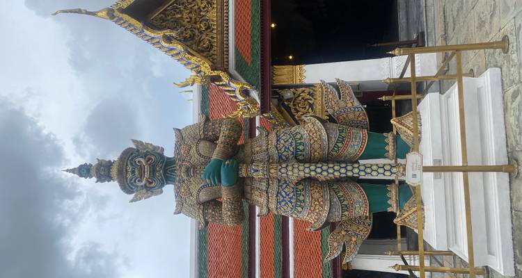 Giant statue at a temple with ornate architecture.