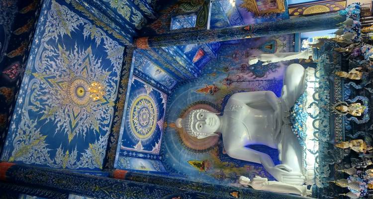 Interior de templo elaboradamente decorado con una gran estatua de Buda.