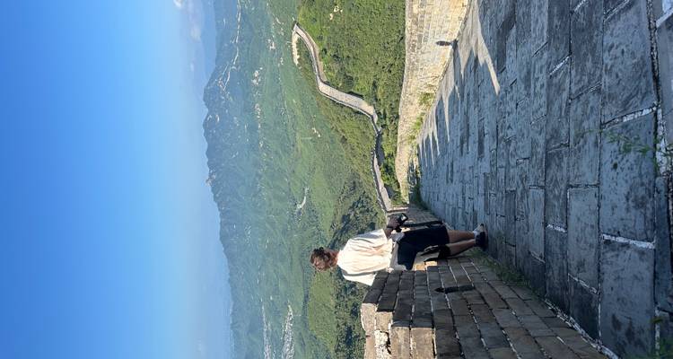 Personne debout sur la Grande Muraille de Chine avec une vue panoramique sur les montagnes.