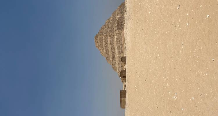 The Step Pyramid in a desert landscape with a clear blue sky.