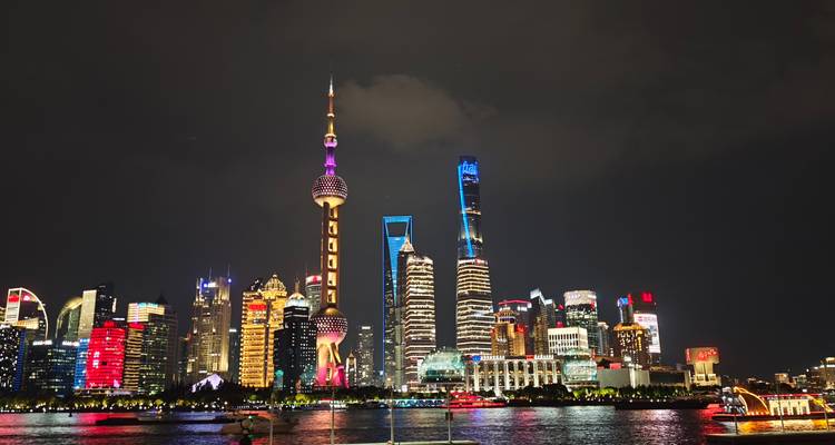 Shanghai skyline at night with illuminated skyscrapers.