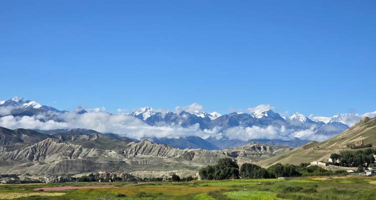 Mountainous landscape with clear skies and distant snow-capped peaks.