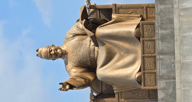 Statue of a seated figure holding a book.