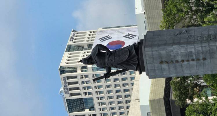 Statue of a standing figure with a historical building.