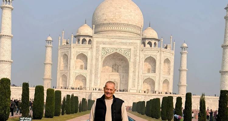 Person, die vor dem Taj Mahal mit Gärten und einem Marmorweg steht.