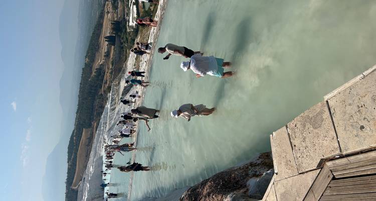 Des gens pataugeant dans les terrasses de travertin de Pamukkale.