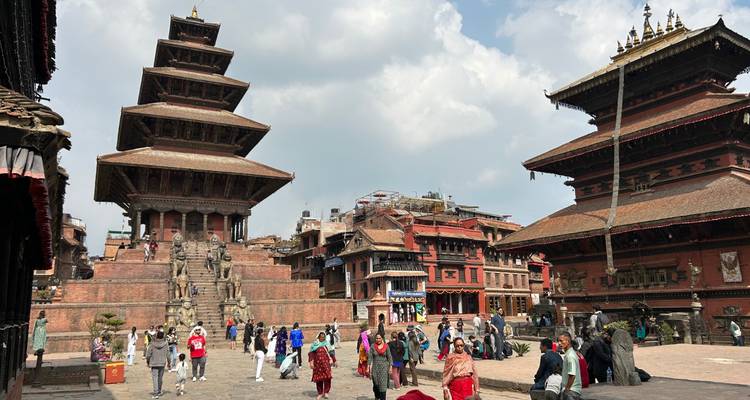 Historic square with temples and people walking around.