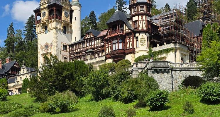 Palace with intricate architecture surrounded by lush greenery under clear blue skies.