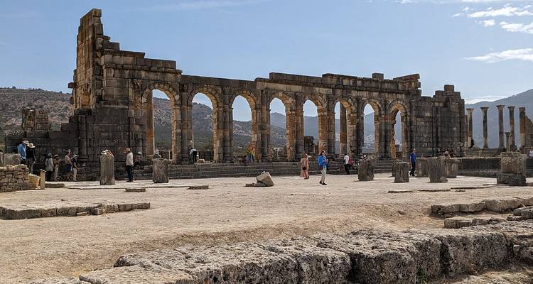 Ruines romaines avec colonnes sous un ciel bleu.