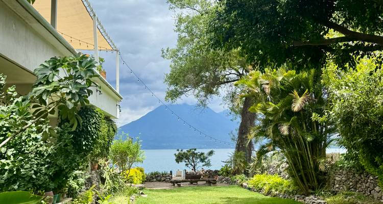 Jardin luxuriant avec vue sur une montagne lointaine et un lac.