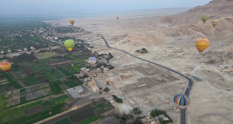 Montgolfières au-dessus de champs et de ruines.