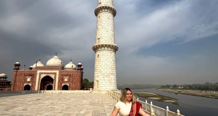 Femme posant devant le minaret du Taj Mahal et la vue sur la rivière.