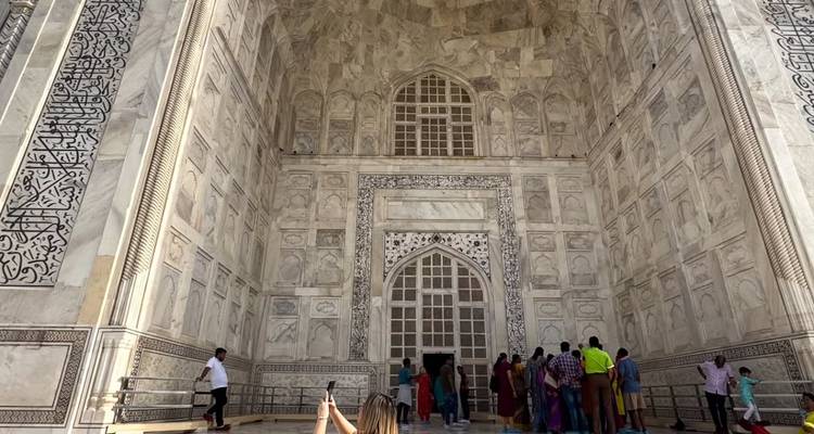 Touristes à l'entrée du Taj Mahal, mettant en valeur les détails architecturaux complexes.