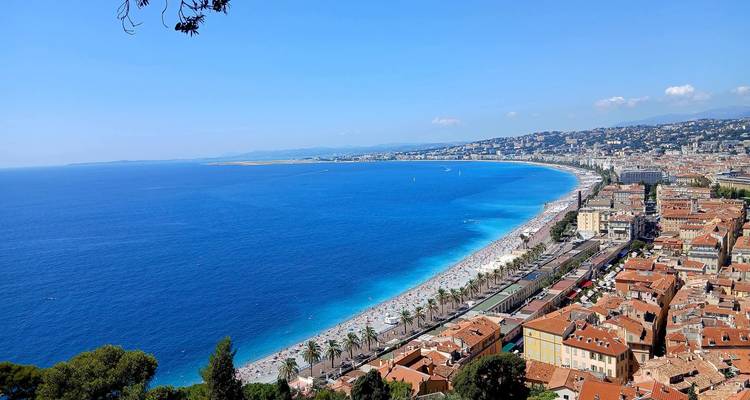 Vue aérienne d'une ville côtière avec un front de mer en arc de cercle.