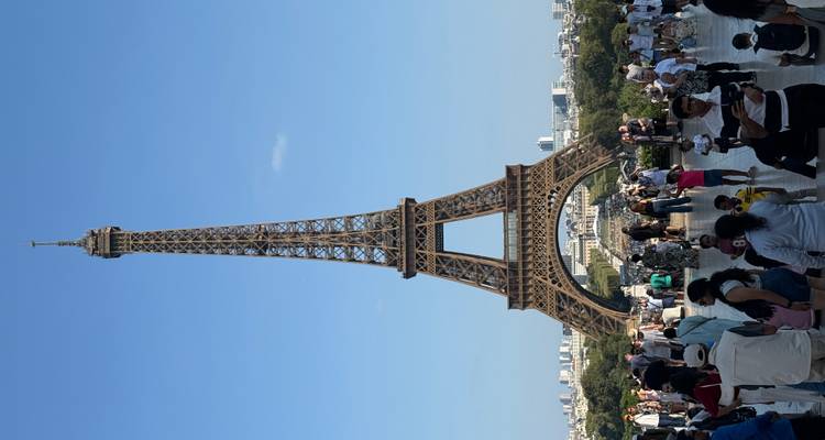 A bustling tourist scene with the Eiffel Tower in the background.