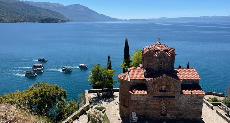 A historic church overlooking Lake Ohrid with boats on the water.