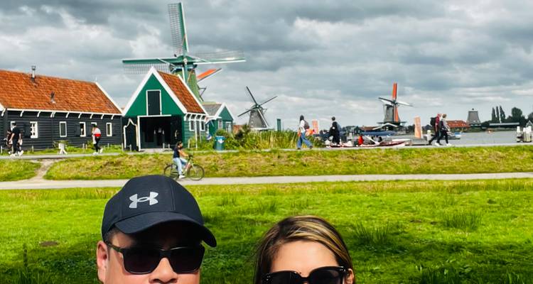 Couple with a backdrop of windmills in a scenic countryside.