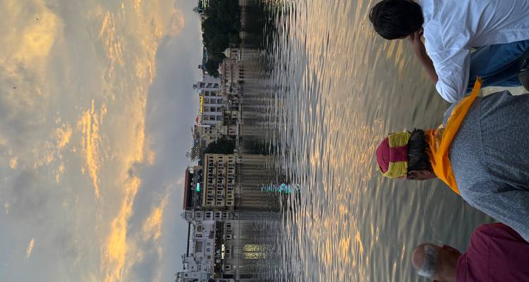 People sitting by a lake during a sunset.