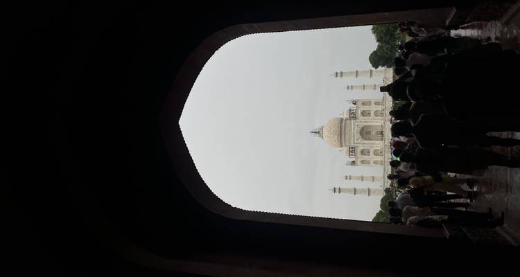 Multitud viendo el Taj Mahal desde una entrada arqueada.