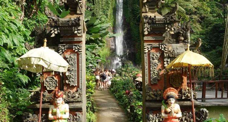 Pathway leading to a waterfall with traditional Balinese gate.