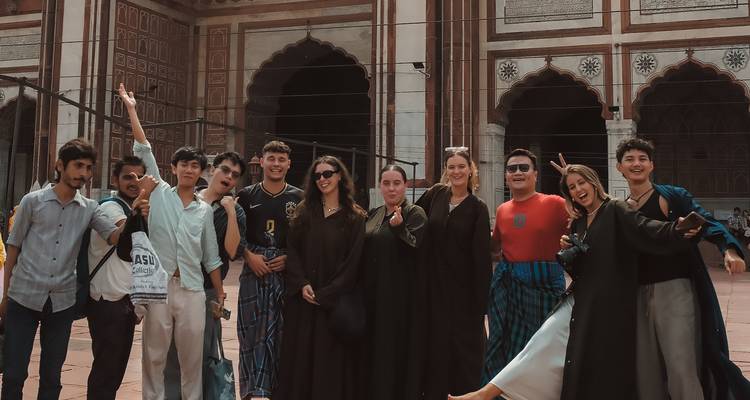 Grupo frente a un edificio histórico en India.