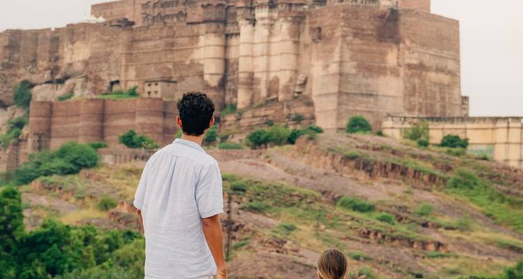Persona observando un gran fuerte en India.