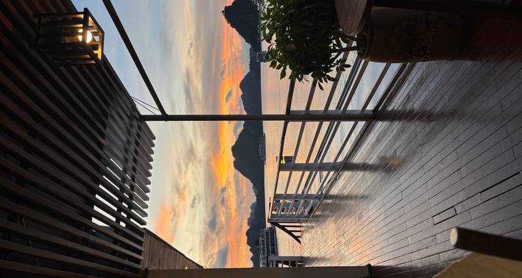 View from a boat deck at sunset with scenic limestone formations in the bay.