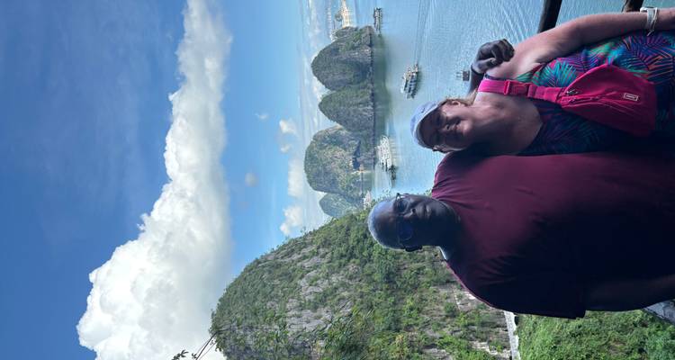 Two people posing with the scenic Halong Bay islands in the background.
