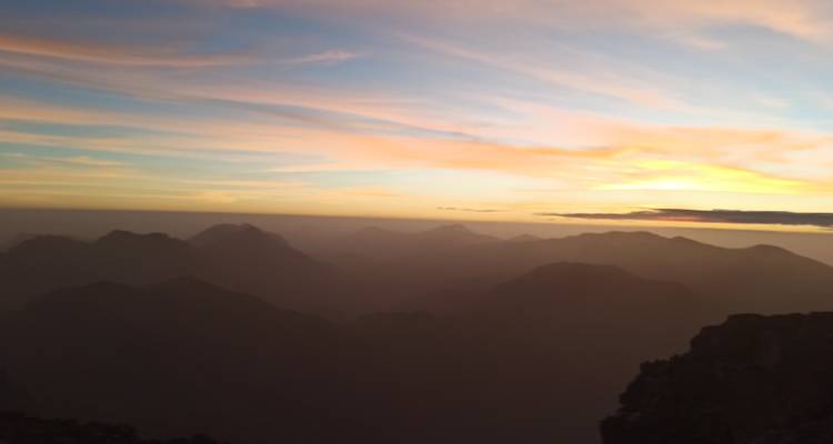 Une silhouette de montagnes pendant un coucher de soleil coloré.