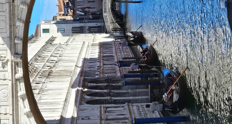 Gondoleros venecianos remando por un canal.