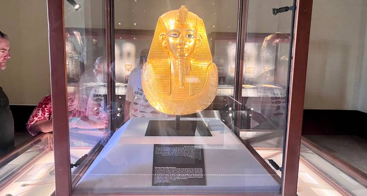 Golden burial mask displayed in a museum.