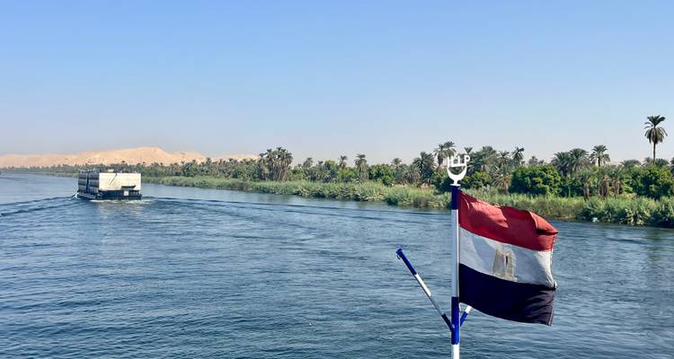 Nile river with boat and Egyptian flag.