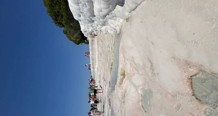 Rocky limestone terraces with people walking around.