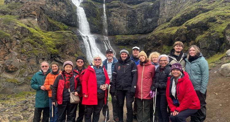 Eine Gruppe von Menschen posiert vor einem Wasserfall.