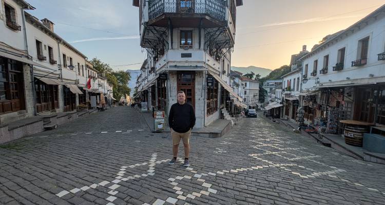 Personne debout au milieu d'une rue pavée entourée de bâtiments historiques.